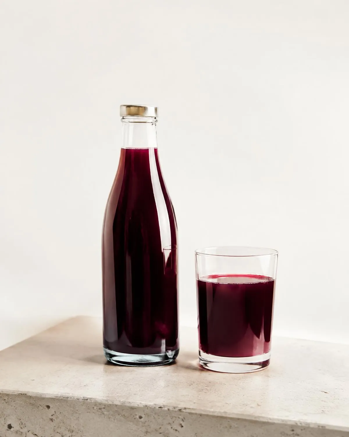 Bouteille et verre de jus de raisin sur une pierre